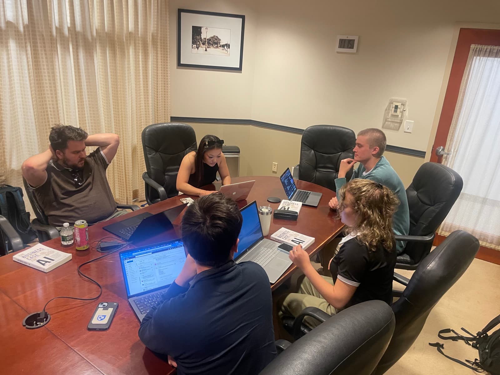 The team mid working session around a conference table, laptops open